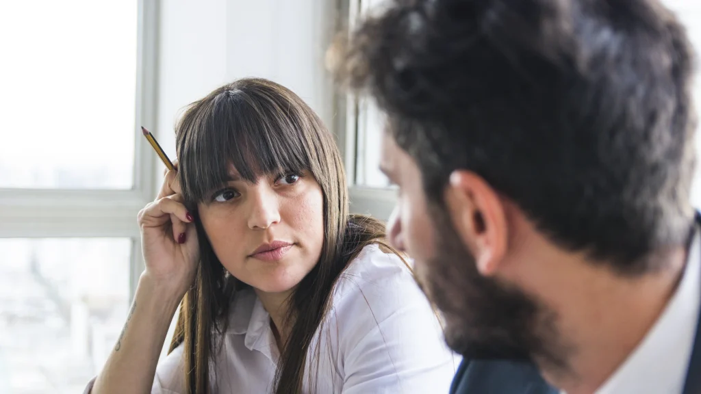 Mujer con discriminación auditiva que le cuesta seguir una conversación de trabajo